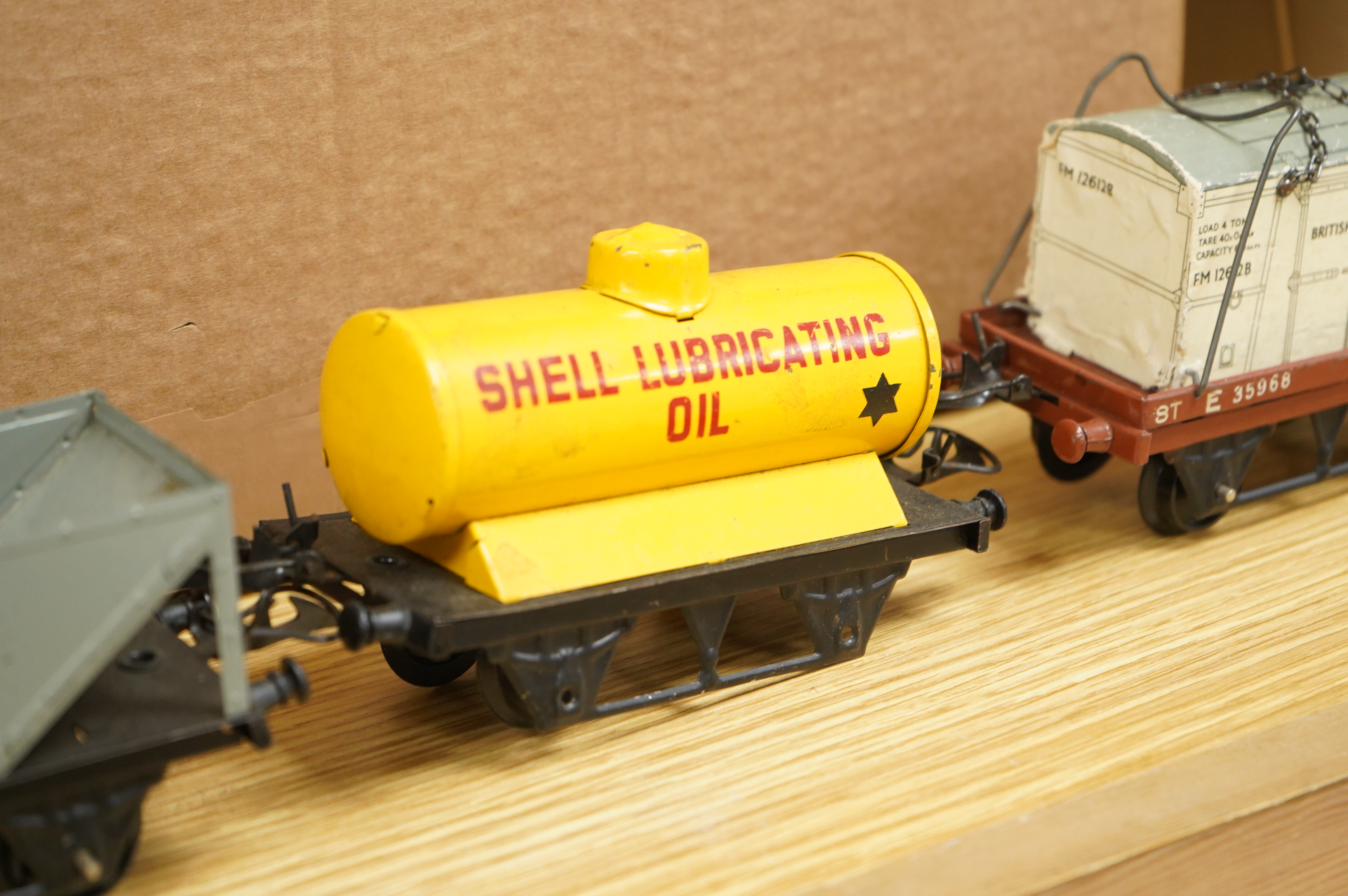 A collection of 0 gauge Hornby tinplate clockwork railway, including four BR locomotives, 17 freight wagons and four wheel coaches, together with a station building, signal cabin, and Goods depot (missing base), plus a f